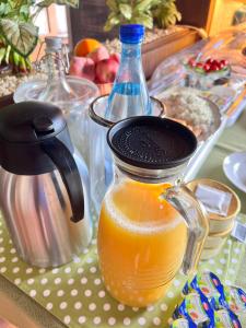 - une carafe de jus d'orange et une bouteille d'eau dans l'établissement Landgasthof Zum Anker, à Langenfeld