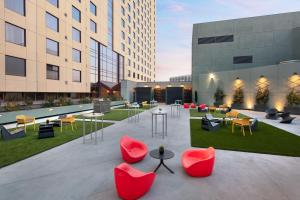 a courtyard with red chairs and tables and buildings at Oakland Marriott City Center in Oakland