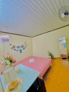 a room with a bed and a table with flowers on it at Rose's House in Khu Chi Lăng