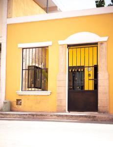 un edificio amarillo con una puerta y ventanas negras en Casa Fundadores, en Valladolid