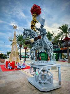 une statue d'une femme sur un cheval et un arbre de Noël dans l'établissement El mundo soleado, à Santa Pola