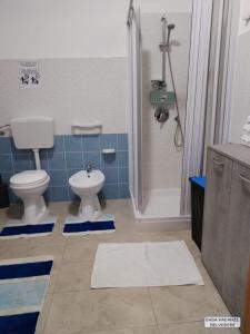 e bagno con servizi igienici e doccia con piastrelle blu. di Casa Belvedere a Portopalo