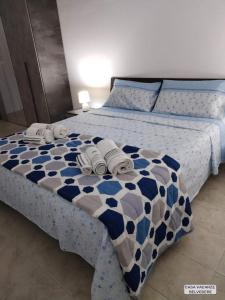 una camera da letto con un letto e asciugamani di Casa Belvedere a Portopalo