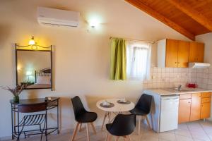 a kitchen with a table and chairs and a small table at Rousis Studios in Parga