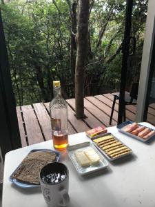 uma mesa com comida e uma garrafa de álcool e bolachas em Cabaña de montaña espectacular em Liberia