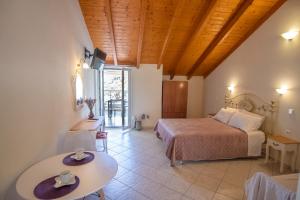 a bedroom with a bed and a table in a room at Rousis Studios in Parga
