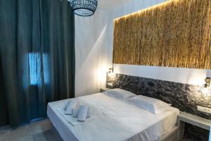 een slaapkamer met een bed met twee handdoeken erop bij Vlychada's Diamond Apartments in Vlychada