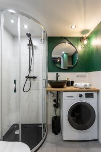 a bathroom with a shower and a washing machine at Golden Apartments Warsaw - Stylish Luxury, Złota Street in Warsaw