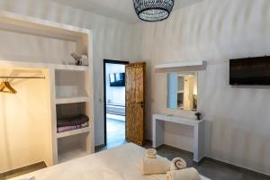 a room with a bed and a tv and a mirror at Vlychada's Diamond Apartments in Vlychada