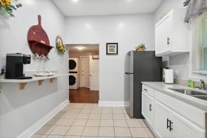 a kitchen with white cabinets and a black refrigerator at ATL Home Close to Airport, Tyler Perry, Betline home in Atlanta