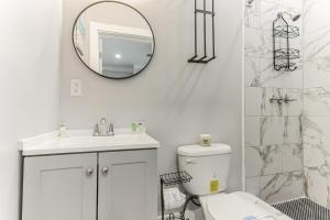 a white bathroom with a toilet and a mirror at ATL Home Close to Airport, Tyler Perry, Betline home in Atlanta