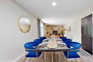 a dining room with a long table and blue chairs at Magnolia Place in New Buffalo