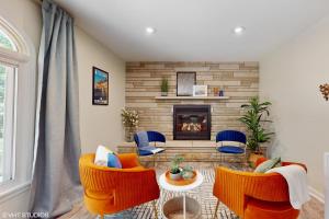 a living room with orange chairs and a fireplace at Magnolia Place in New Buffalo