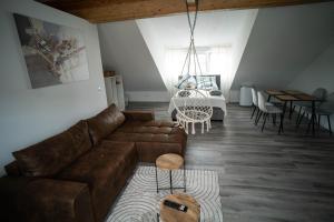 ein Wohnzimmer mit einem braunen Ledersofa und einem Tisch in der Unterkunft Barockes Refugium I 10 Minuten zum Europa-Park in Ettenheim