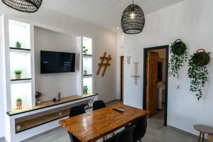 ein Esszimmer mit einem Holztisch und einem TV in der Unterkunft Vlychada's Diamond Apartments in Vlychada