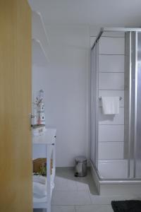 biała łazienka z prysznicem i umywalką w obiekcie Ferienwohnung am Holdereggenpark w mieście Lindau