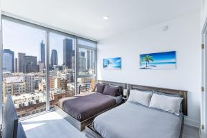 1 dormitorio con 2 camas y ventana grande en Top Floor 3 Bed 3 Bath Penthouse Living In Luxury, en Los Ángeles