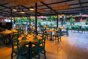 un restaurante con mesas y sillas de madera y una habitación grande en Natural Lodge Caño Negro, en Caño Negro