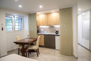 a kitchen with a table and chairs in a room at Naiads Nest - The Ground Junior in Varkiza