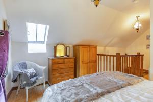 a bedroom with a bed and a dresser and a chair at Miller's Lodge in Liskeard