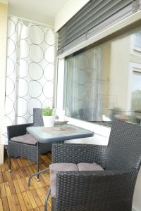 patio ze stołem i krzesłami oraz oknem w obiekcie Ferienwohnung am Holdereggenpark w mieście Lindau