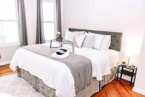 1 dormitorio blanco con 1 cama grande con almohadas blancas en 5BR triple decker apartment – 15 mins to City en Boston