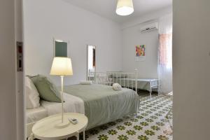a bedroom with a bed and a couch and a table at Le Sorelle Villa sul mare in Porto Empedocle