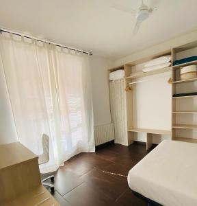 um quarto com uma cama, uma secretária e uma janela em La Fonda de la Calle Ancha em Guadix