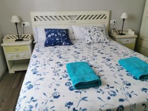 1 cama con sábanas azules y blancas y almohadas azules en San Pedro, en Cangas de Foz