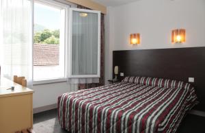 a hotel room with a bed and a window at Hôtel Sainte Suzanne in Lourdes +30 photos