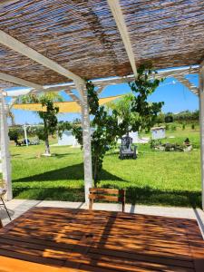 a patio with a bench and a field of grass at Villa Andrea San Lorenzo in Noto