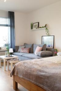 una sala de estar con un sofá azul en una habitación en Ferienwohnung am Holdereggenpark, en Lindau
