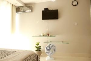 a bedroom with a fan and a tv on the wall at Apt Multishoping no centro do núcleo bandeirante in Núcleo Bandeirante