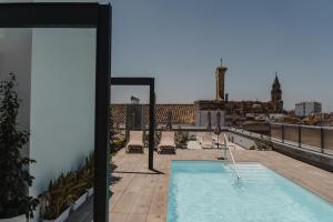 a swimming pool on the roof of a building at esZentrico Suites Jerez in Jerez de la Frontera
