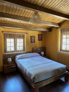 um quarto com uma cama grande e 2 janelas em Casa Miravalles Fornela 