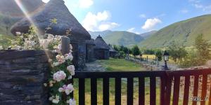 a balcony with a view of a stone building with flowers at Casa Miravalles Fornela 