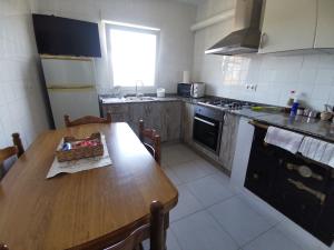 a kitchen with a wooden table and a kitchen with a stove at San Pedro in Cangas de Foz