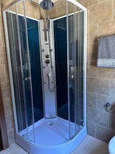 um chuveiro com portas de vidro na casa de banho em Casa Miravalles Fornela 