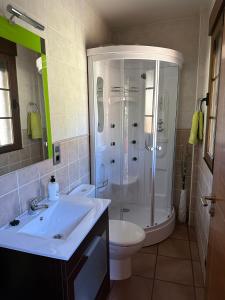 uma casa de banho com um lavatório, um chuveiro e um WC. em Casa Miravalles Fornela 