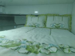 Una cama con sábanas blancas y flores. en A 5 km do aeroporto no centro do Nucleo Bandeirante, en Brasilia