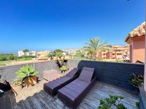 een balkon met 2 paarse stoelen en een tafel bij PUSHE Penthouse Playa Granada Beach & Golf 2 in Motril