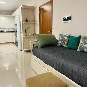 ein Wohnzimmer mit einem Sofa und einer Küche in der Unterkunft Depto Tatiana zona céntrica Carlos Paz in Villa Carlos Paz