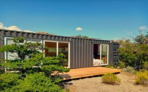 a tiny house in the desert with a wooden deck at Aizeder - Eco Container in El Chalten