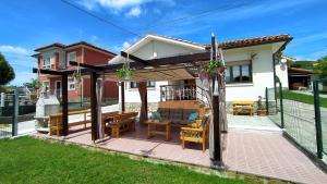 una pérgola con un banco y una mesa en Casa la Juncara, en Guarnizo