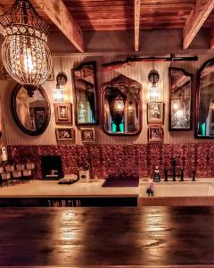 Cedar Oaks Inn The Birdcage Saloon في ديكنسون: حمام فيه مغسلتين ومرايا وثريا