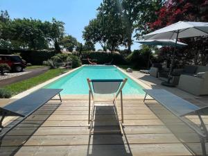 une chaise assise en face d'une piscine dans l'établissement Villa avec piscine Andernos les Bains, à Andernos-les-Bains