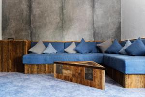 a blue couch with pillows and a coffee table at Hotel Gasthof Eder GmbH in Gmund am Tegernsee