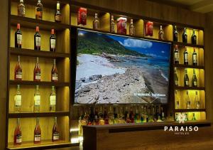 トルヒーリョにあるHoteles Paraiso TRUJILLOのワインのボトルとテレビの表示