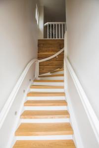 una escalera en una casa con paredes blancas y suelo de madera en Jüri tn Apartment B, en Võru