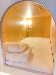 札幌市にあるシティキャビンすすきののアーチ型の窓が付いたベッドが備わる客室です。